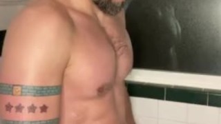 Bearded jock rubs piss all over chest