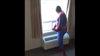 spiderman in black silicone mask jerking off at hotel window