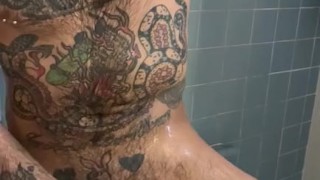 Tattooed and hairy hunk scrubs down in the shower