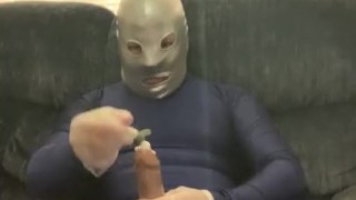 Jacking off condomed dildo with lotion in full blue spandex suit