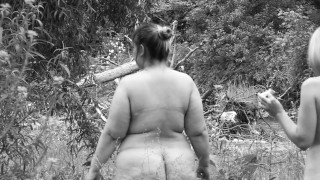 Lesbian girlfriends draw on each other's body outdoors.