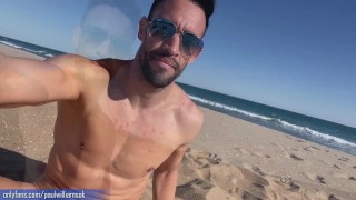 Fitness young man gets naked on Barcelona public beach after gym workout