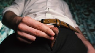 Sexy guy in a suit jerks off close-up, moans with pleasure and cums in a condom.