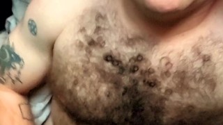 Hairy tattooed guy jerks off big cock and eats cum
