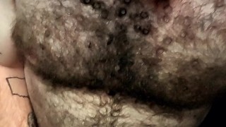 Hairy tattooed guy jerks off big cock and eats cum