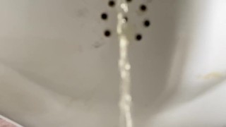 Pissing boy in a public toilet slow-mo