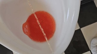 Pissing in a public urinal toilet