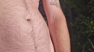 Pissing out door wearing jeans