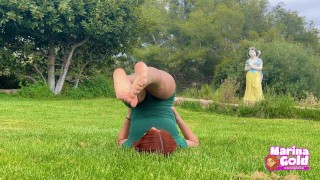 Pelirroja hace estiramientos sensuales de Yoga en el parque para que la observen