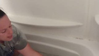 Sexy girl giving angry kitten a bath in short shorts