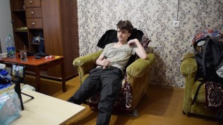 a guy in a black jacket on a chair jerks off his dick and cums a lot of sperm
