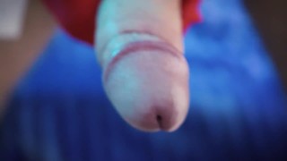 A man masturbates his penis on a chair wearing red and white gloves