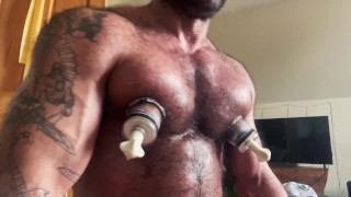 Muscle Daddy uses his nipple suckers and dick pump.