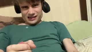 A guy jerks off in a green T-shirt and cums with sperm on the T-shirt