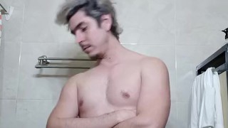 Guapo flexionando músculos en el baño, verga grande