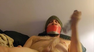 Tightly gagged with duct tape, cock and balls socked