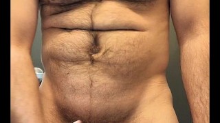 Hairy muscle stud flexing and stroking cock in public restroom