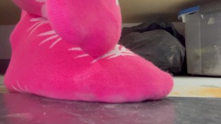 Playing with my pink weed socks under the table