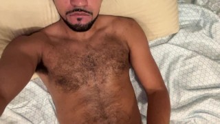 Hairy guy jerking off in bed quickly cums on himself
