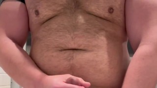 Beefy man in public restroom strips down spits and jerks on thick cock before cumming