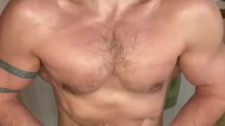 Bearded jock flexes in bathroom