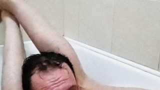 Legs behind the head in a bathtub while touching my cock and showing off feet soles