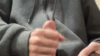 A guy in a gray sweater on a chair cums with a waterfall