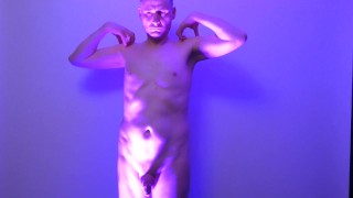 Man posing naked in a blue light his uncut cock shaved and flaccid shows off his nude body