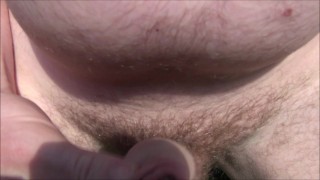 squatting down to pee in the grass