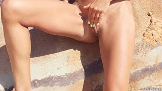 Sexy brunette fitness babe masturbates her beautiful pussy at a public beach - Risky Adventure