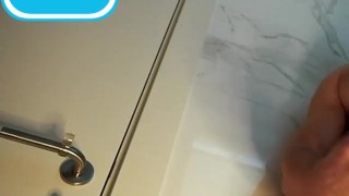 Handsome guy with blue eyes fingering his big dick in the toilet