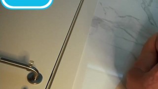 Handsome guy with blue eyes fingering his big dick in the toilet