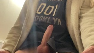 The guy plays with a dick, on a chair, cums on a T-shirt