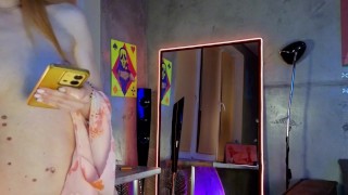 Cutie in a beautiful dress striptease in front of the mirror