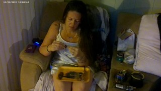 Busty girl in pink bra and panties smoking and playing video games