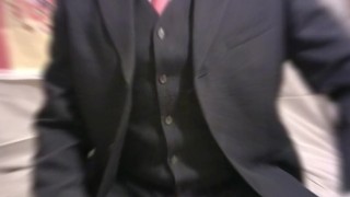 corbata roja, traje azul marino con chaleco mostrando miembro