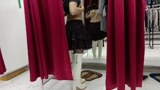 An exhibitionist wife tries on clothes in a store in public with an open curtain