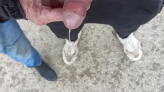 Friend is holding my cock while im peeing on the ground outdoor