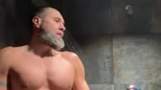 Bearded muscular jock pisses in gym locker room shower