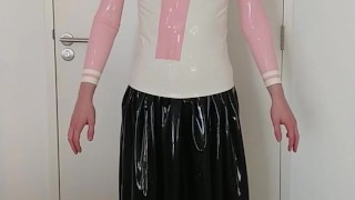 Putting on pink frilly latex blouse over long rubber skirt, maid stockings, panties, layers
