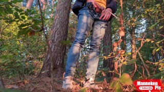 Guy long pissing in the forest under a tree