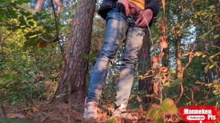 Guy long pissing in the forest under a tree